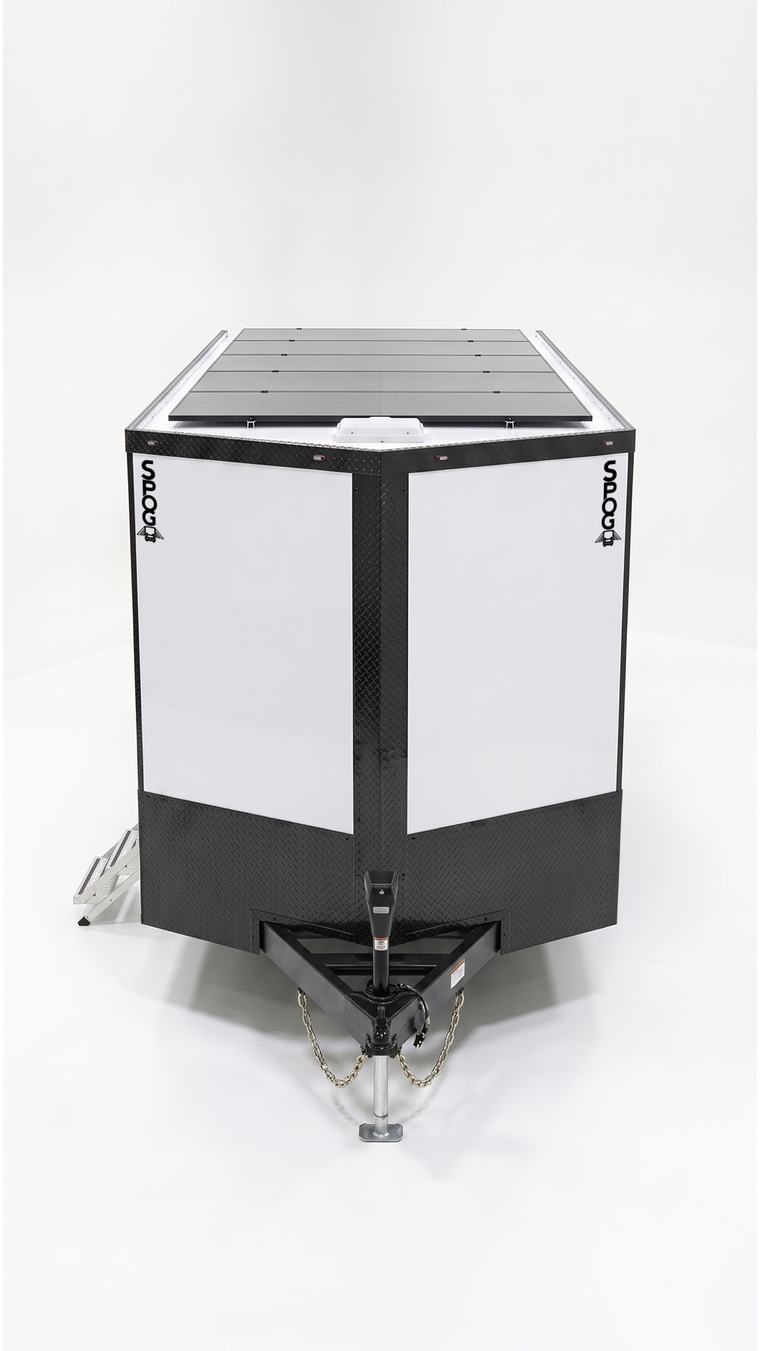Front view of a SPOG trailer showing the roof-mounted solar array, diamond-plate nose, tongue jack, and fold-out entry stairs.