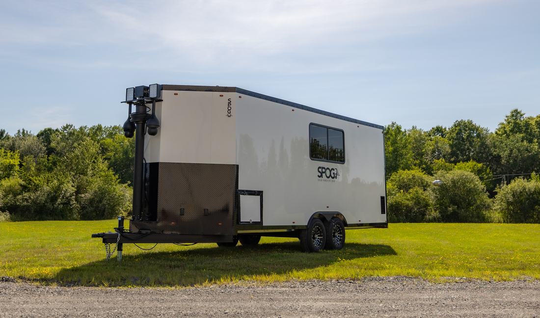 Side profile of the SPOG trailer showing the diamond-plate lower skin, side window, and telescoping light and camera tower.